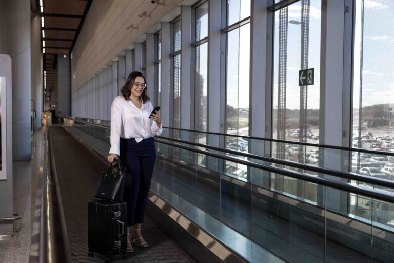 mulher usando celular na viagem a trabalho